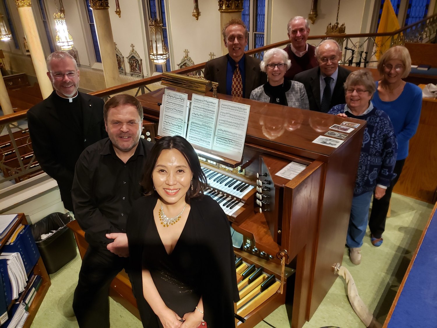 Father Jeremy Secrist, visiting organist Horst Buchholz, visiting vocal soloist MeeAe Cecilia Nam and members of the local American Guild of Organists chapter stand next to the organ console in the choir loft of St. Peter Church in Jefferson City, following an Oct. 20 public concert of music for organ and voice.
